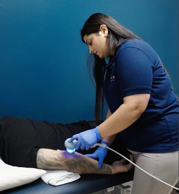 Registered physiotherapist providing shockwave therapy treatment to a patient at Revive Rehab Surrey