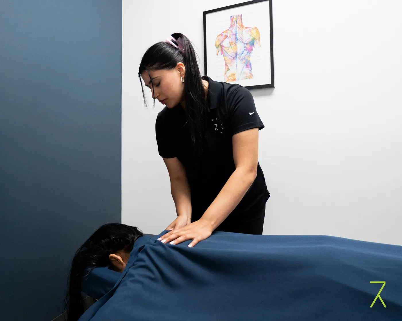 Registered massage therapist performing hands-on treatment at Revive Rehab